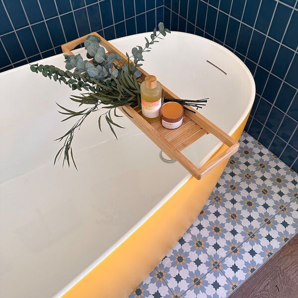 yellow free standing bath with blue wall tiles 